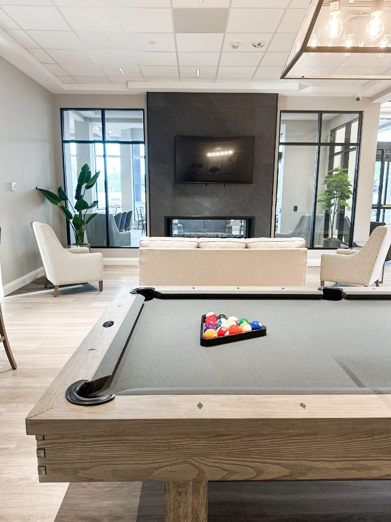 Pool table and fireplace in main lobby of Lanark Lifestyles Luxury Senior Apartments
