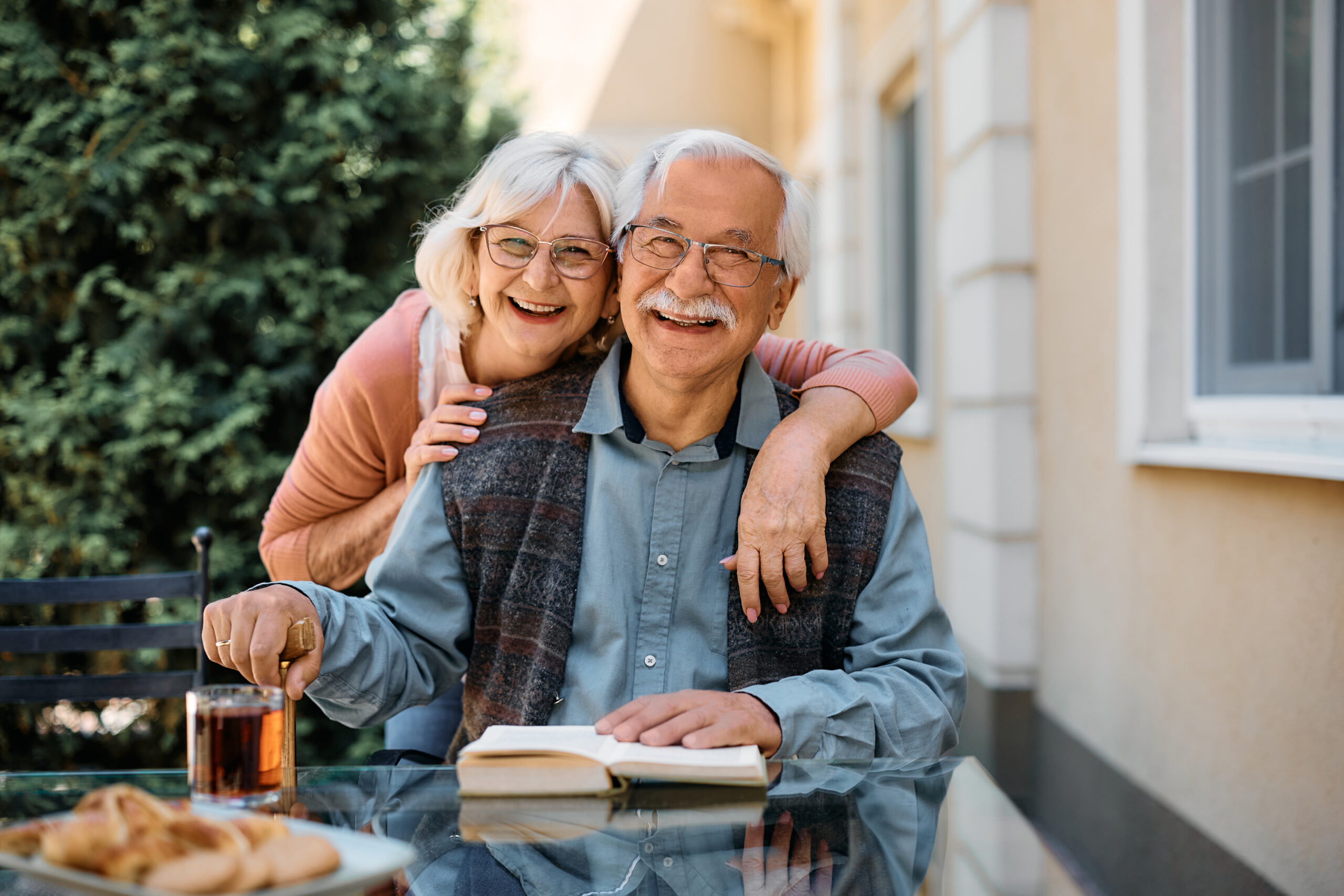 A happy senior couple enjoying time outside of their retirement home.